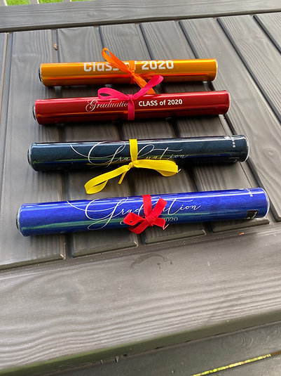 Four Showball graduation scrolls in gold, red, black and blue, each tied with a ribbon