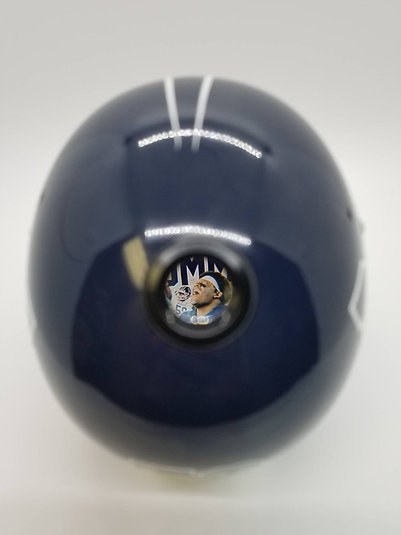 Close-up of a navy Showball mini helmet with a player photograph visible through the eyepiece