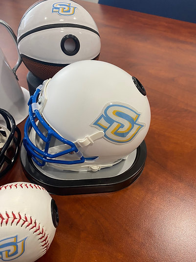 A Showball mini helmet, basketball and baseball in matching Southern University team branding